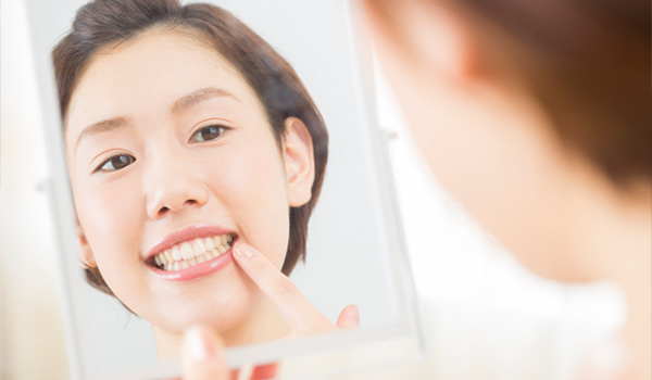 鏡で歯をみる女性